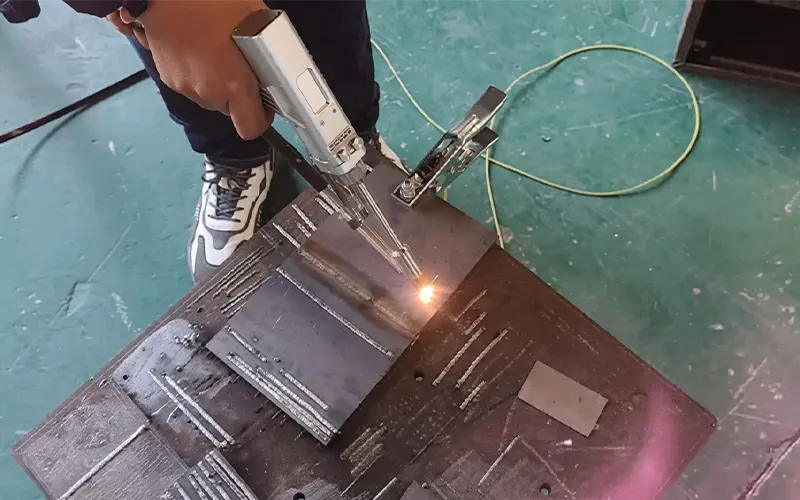 laser welder operator wearing OD6 safety goggles with nozzle contact sensor engaged on stainless steel workpiece